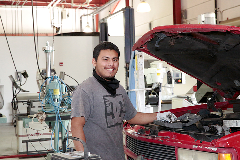 View Program Automotive Technology Man with his hand under hood of a car