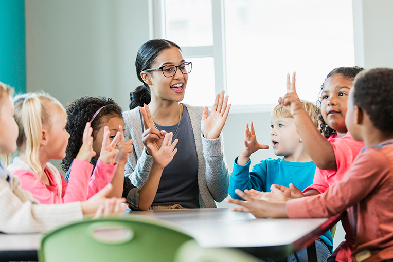 View Program Child Development Teacher with students counting fingers